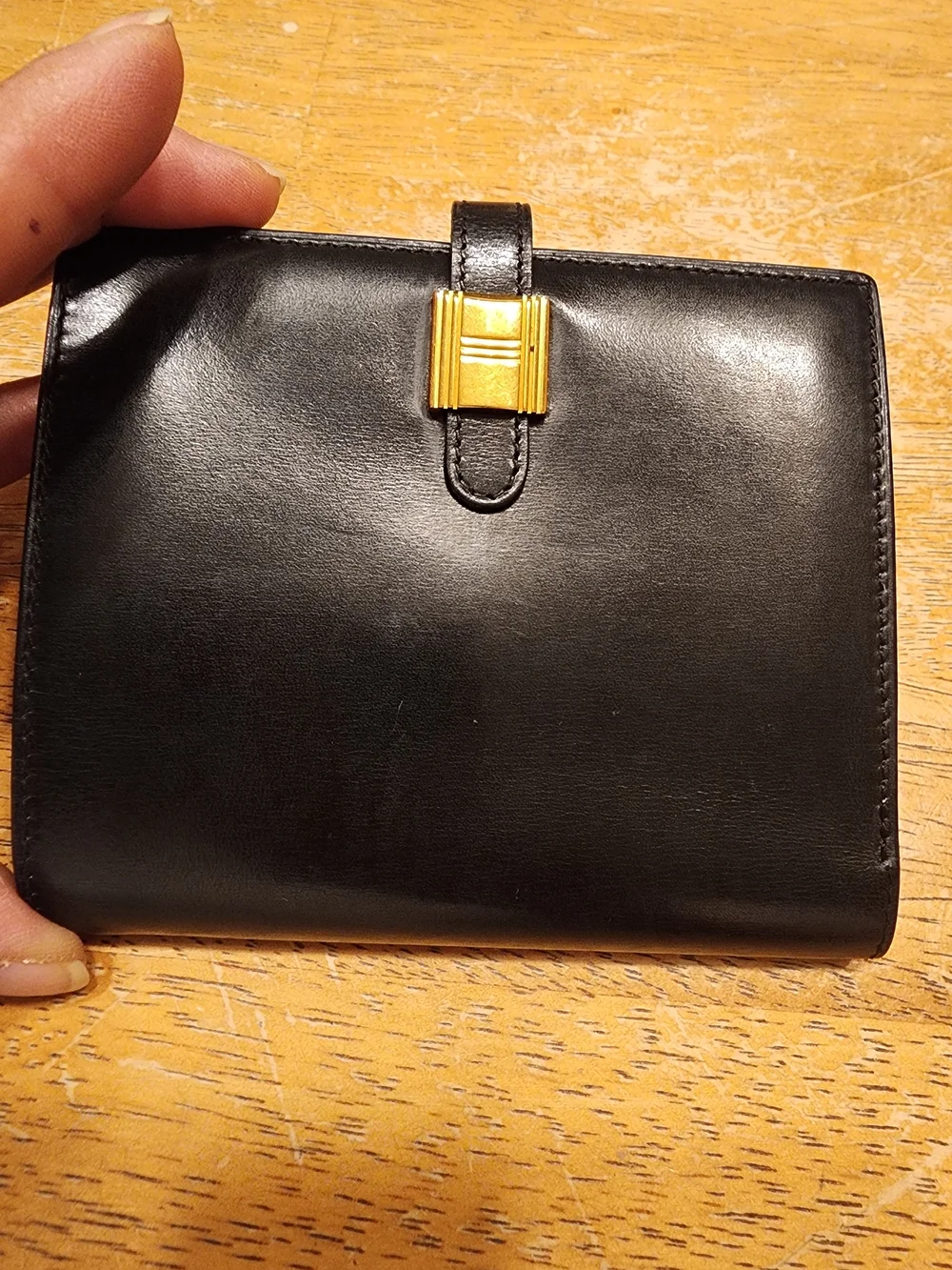 vintage Hermès Saumur Diane bi-fold wallet is crafted smooth black box calfskin